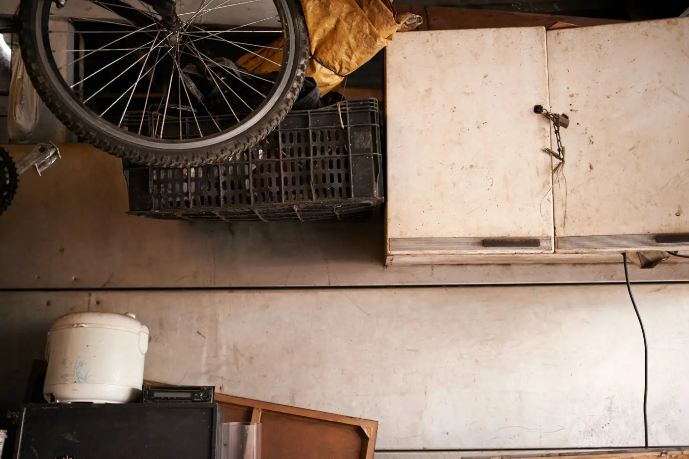 Cluttered garage storage with a bicycle and stacked household items